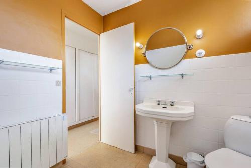 une salle de bain avec un lavabo et un miroir et des toilettes dans l'établissement Notre Maison de Sète, à Sète