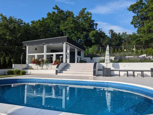 a swimming pool in front of a house at Čudna šuma apartmani Vrdnik in Vrdnik