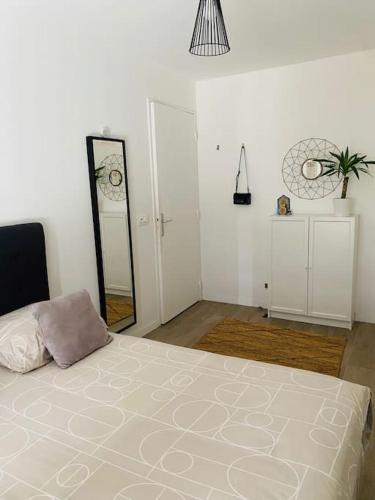 une chambre blanche avec un lit et un miroir dans l'établissement A cosy 2 bedroom flat, à Villeneuve-la-Garenne