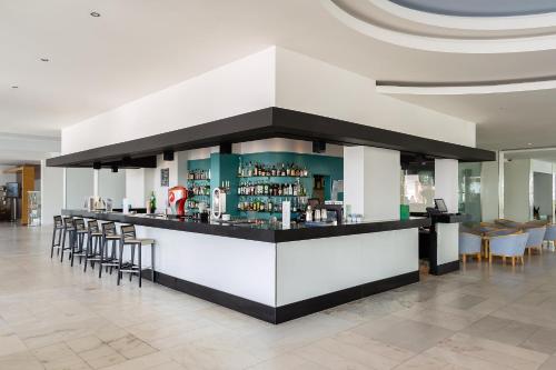 a bar in a lobby with chairs and a counter at Jupiter Algarve Hotel - Beach & Spa in Portimão