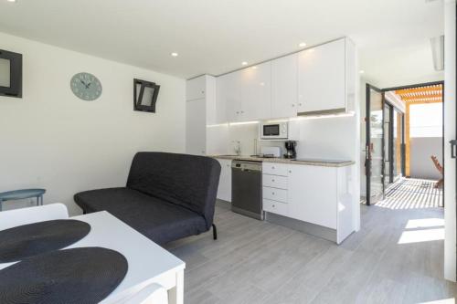 a kitchen with a couch and a chair in a room at Another Side in Furadouro