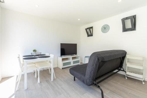 a room with a bed and a table and a tv at Another Side in Furadouro