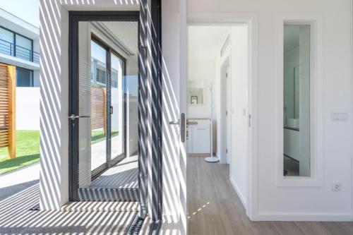 a hallway with a glass door and a staircase at Another Side in Furadouro