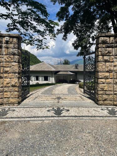 an open gate to a house with a driveway at The Iconic Lodge in Bellagio