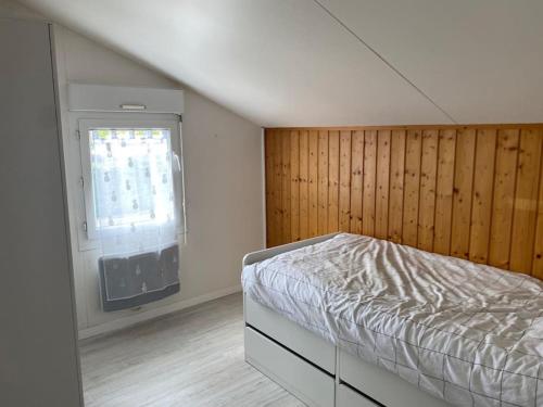 un dormitorio con una cama y una ventana en Chalet familial La Hume, en Gujan-Mestras