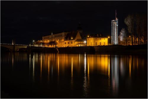 a city lit up at night next to a body of water at App cosi Ile Saint Laurent Chalon Sur Saone in Chalon-sur-Saône