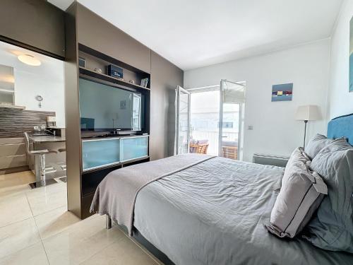 une chambre avec un grand lit et une télévision à écran plat dans l'établissement CAM3 - Beau 2 pièces avec terrasse, à Cannes