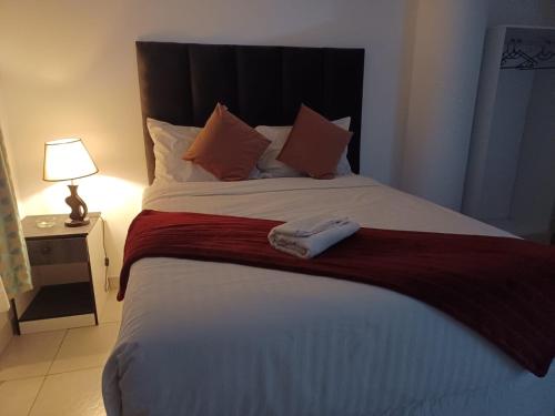 a bedroom with a large bed with a towel on it at De Bliss Lodge in Johannesburg
