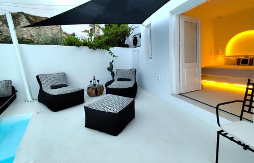 a room with a bed and chairs and an umbrella at The Magic Luxury Cave Suites in Vóthon