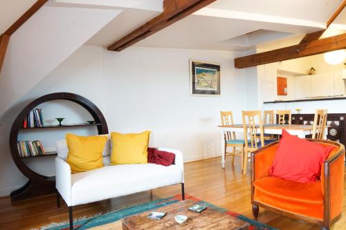 - un salon avec un canapé blanc et deux chaises orange dans l'établissement EXIGEHOME - T3 centre-ville proche de Paris la Défense, Champs Elysée, à Rueil-Malmaison