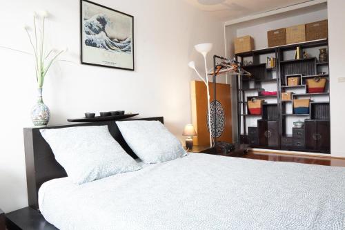 - une chambre avec un lit blanc et une étagère dans l'établissement EXIGEHOME - T3 centre-ville proche de Paris la Défense, Champs Elysée, à Rueil-Malmaison