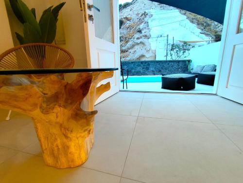 a glass table with a tree stump in a room at The Magic Luxury Cave Suites in Vóthon