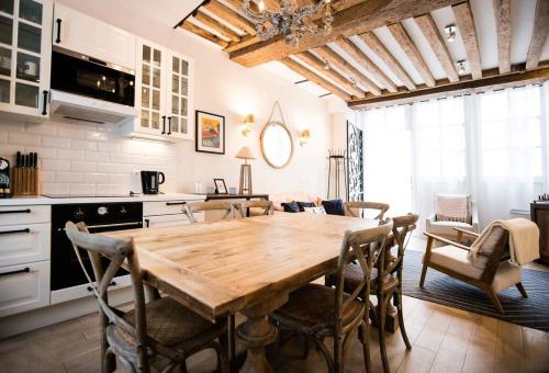 une cuisine et une salle à manger avec une table et des chaises en bois dans l'établissement Classy Bourgeois - Chic 2 Bedroom Apt in Le Marais, à Paris