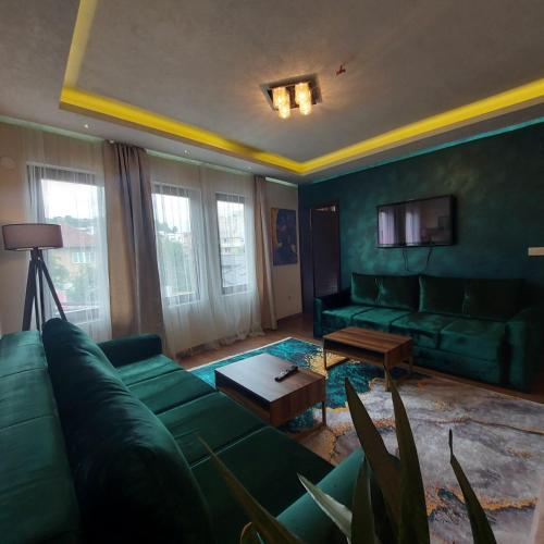 a living room with a green couch and a table at Old City Apartmani Sarajevo in Sarajevo
