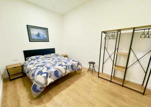 a bedroom with a bed with a blue and white comforter at bcool in Bilbao