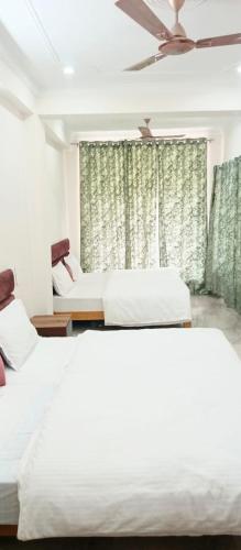 a bedroom with two beds and a window at HOTEL POLL STAR Inn in Barkot