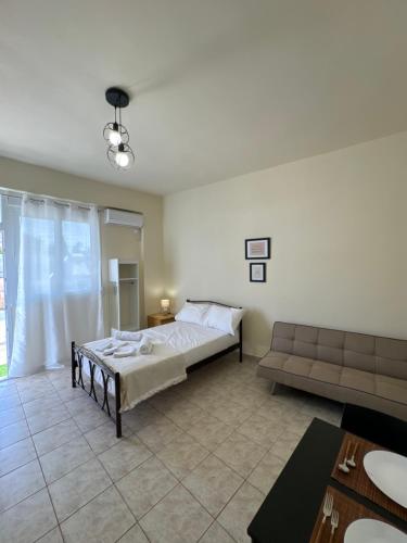 a large bedroom with a bed and a couch at Airpoint Apartments in Artemida