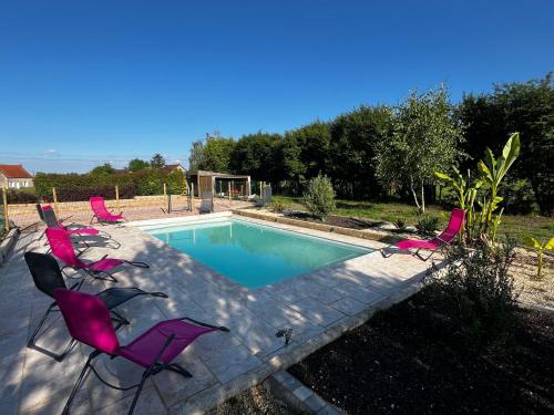 - une piscine avec des chaises roses dans l'établissement Maison 10 personnes avec piscine jacuzzi, proche du PAL, à Boucé
