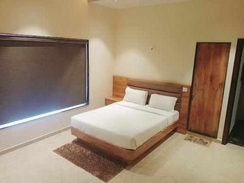 a bedroom with a bed and a large window at Flamingo Club and Resort Una 3 Km Away from Diu Check Post in Diu