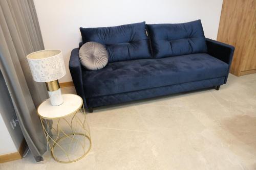 a blue couch in a living room with a lamp at Apartament Królowej Jadwigi z garażem in Radom