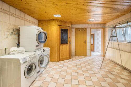 a laundry room with a washing machine and a microwave at Familienhaus in Arnsdorf