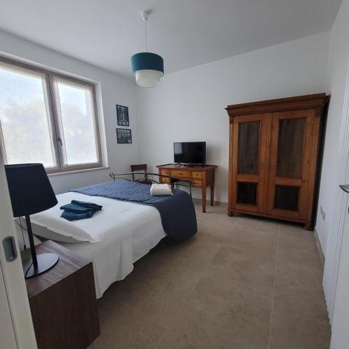 a bedroom with a bed and a wooden cabinet at La Sovrana dei Cimini in Bagnaia