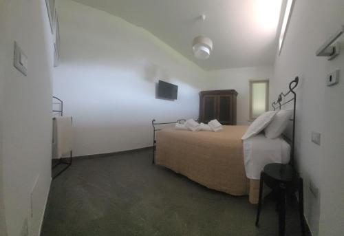 a bedroom with a bed in a white room at La Sovrana dei Cimini in Bagnaia