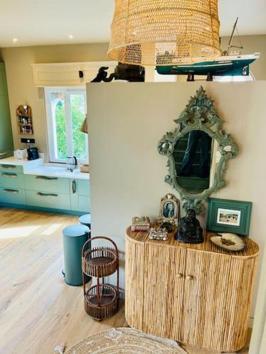 une cuisine avec un miroir et une table avec des chaises dans l'établissement Villa8pers 3'piedplage pleincentre piscine parking, à Arcachon