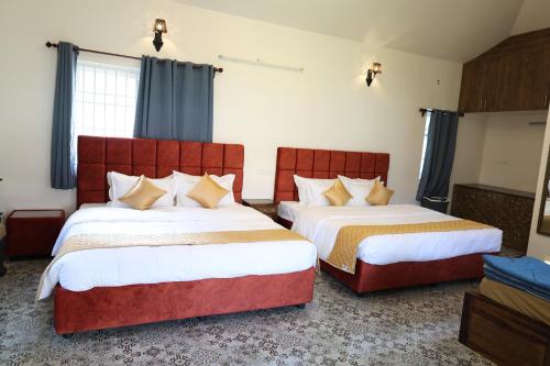 two beds in a hotel room with two bedsitures at Athulya Resort -Leisure and Luxury cottages from EMBEHolidays in Kottaikadu