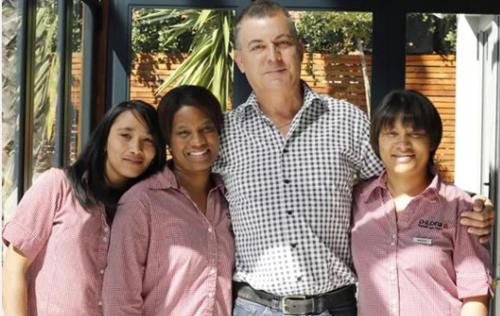 a man and three women posing for a picture at The One 8 Hotel - Solar Power located in Green Point in Cape Town