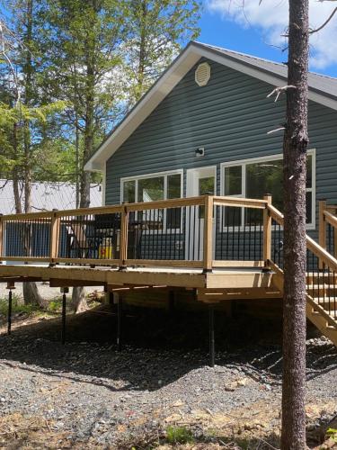 une grande terrasse en bois devant une maison dans l'établissement Blue Heron Cottage Oceanfront and Private trails, à Waweig