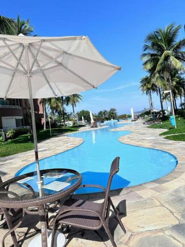 krzesło i parasol obok basenu w obiekcie Apartamento 2 suítes em frente praia de camboinhas w mieście Niterói