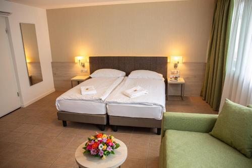 pokój hotelowy z łóżkiem i kanapą w obiekcie Hotel Nessi Locarno w mieście Locarno
