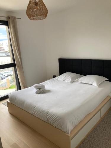 a bed with a black headboard in a bedroom at Annecy L'Arborea in Pringy