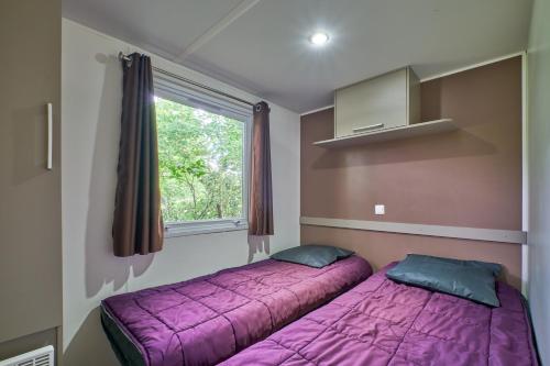 1 dormitorio con 2 camas y ventana en Mobil Home 4 personnes 207, en Mens