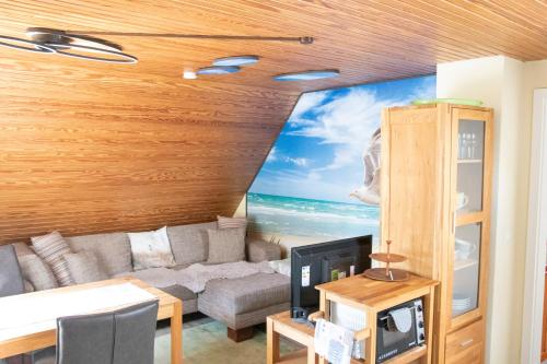 een woonkamer met een bank en een schilderij van de oceaan bij Seeluft in Cuxhaven