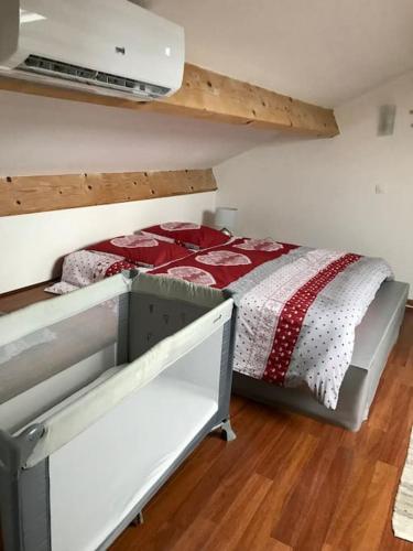 - une chambre dotée d'un lit avec une couverture rouge et blanche dans l'établissement Petit Cocon, à Saint-Laurent-de-la-Prée