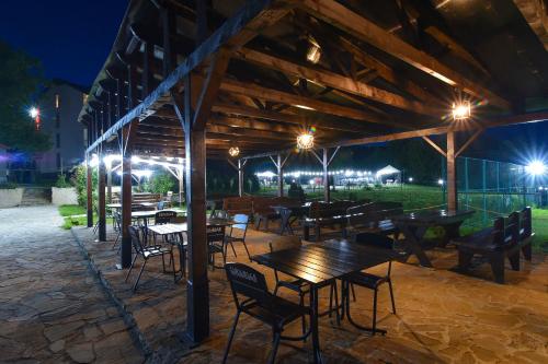 an outdoor patio with tables and chairs at night at Hotel Shaori in Nikortsminda