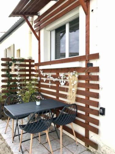 une table et deux chaises devant une clôture dans l'établissement Petit Cocon, à Saint-Laurent-de-la-Prée