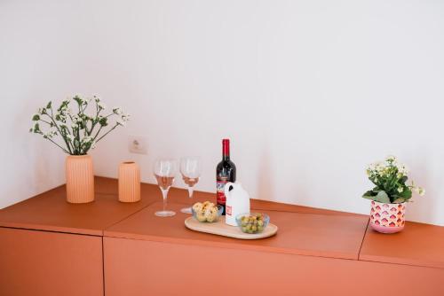 a bottle of wine and wine glasses on a cabinet at Palazzo D'Azeglio in Alberobello