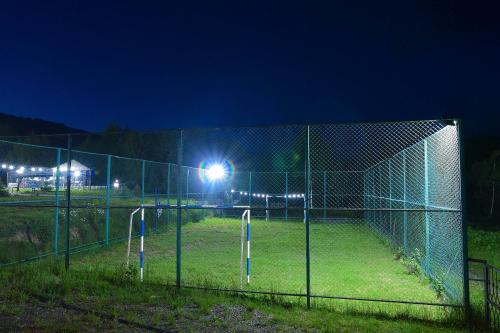 a batting cage at night with lights on it at Hotel Shaori in Nikortsminda
