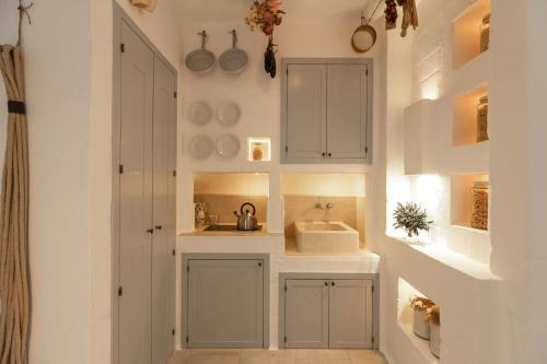 a kitchen with white cabinets and a sink at Borgo Egnazia in Savelletri di Fasano