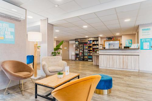 a lobby of a library with chairs and a counter at Kyriad Direct Tours Sud - Chambray Lès Tours in Chambray-lès-Tours
