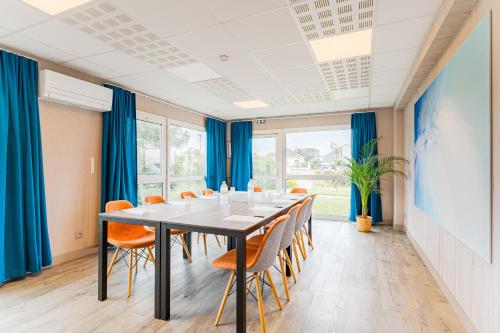 a conference room with a table and chairs at Kyriad Direct Tours Sud - Chambray Lès Tours in Chambray-lès-Tours