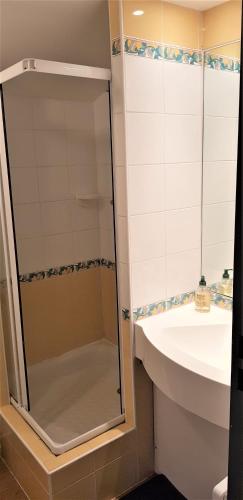La salle de bains est pourvue d'une douche en verre et d'un lavabo. dans l'établissement Appartement T3 au pied des pistes Les Coches, à La Plagne Tarentaise