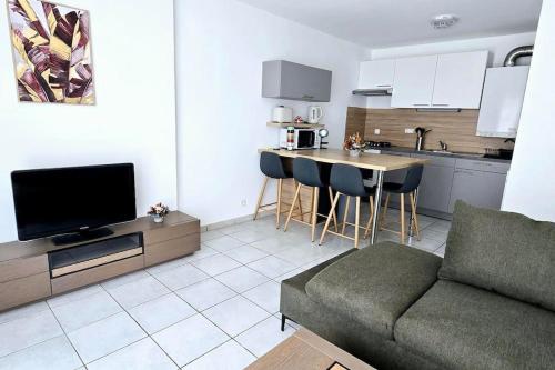 un salon avec un canapé et une cuisine dans l'établissement Le Jérémy avec parking souterrain, à Thonon-les-Bains