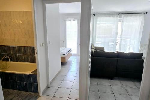 - un salon avec un canapé et une baignoire dans l'établissement Le Jérémy avec parking souterrain, à Thonon-les-Bains