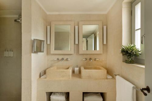 łazienka z 2 umywalkami i 2 lustrami w obiekcie Borgo Egnazia w mieście Savelletri di Fasano