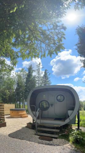 a machine sitting on the ground under a tree at Celtic Minor Pods in Ystalyfera