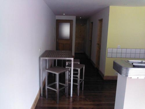 uma cozinha com dois bancos e uma mesa num quarto em Le Panorachic em Satillieu